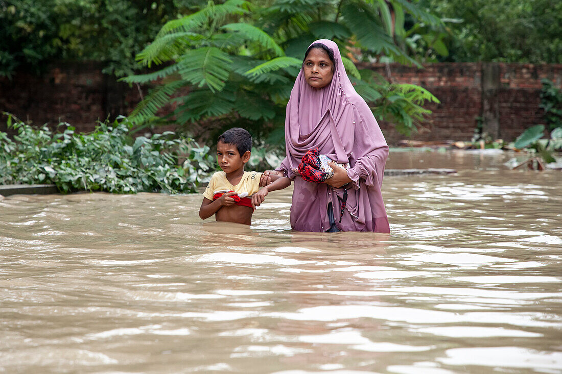 People walking through floodwater, Satkania Upazila, Bangladesh