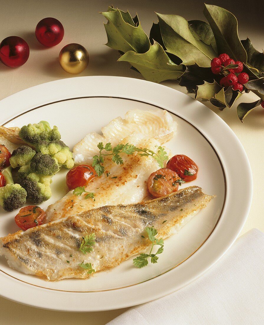 Fried pike-perch with vegetables on plate; holly