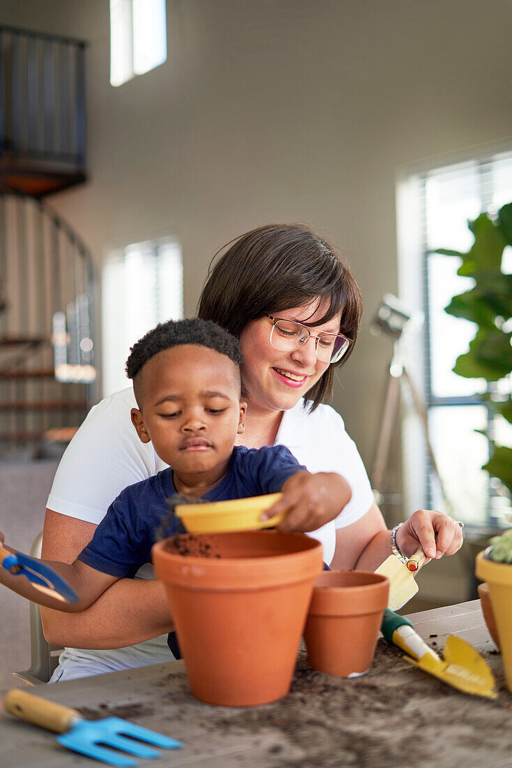 Mother and son planting plants in flowerpots