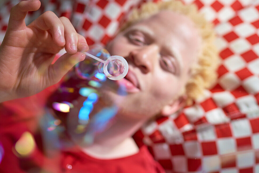Young man blowing bubbles with bubble wand