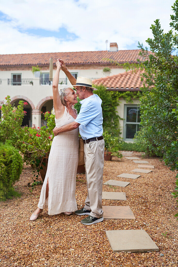 Senior couple dancing in summer garden
