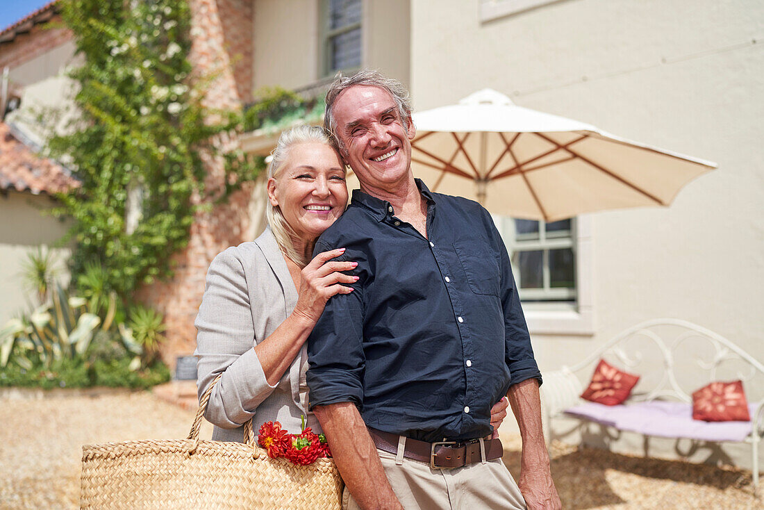 Senior couple hugging on sunny villa patio