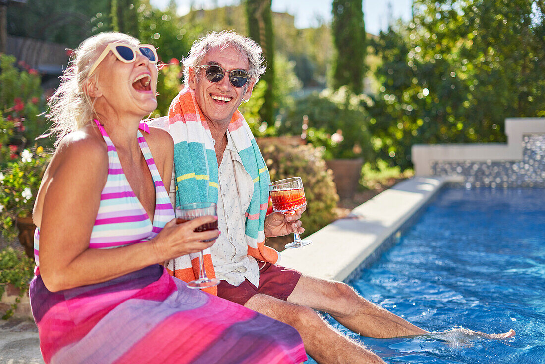 Senior couple laughing at summer swimming pool