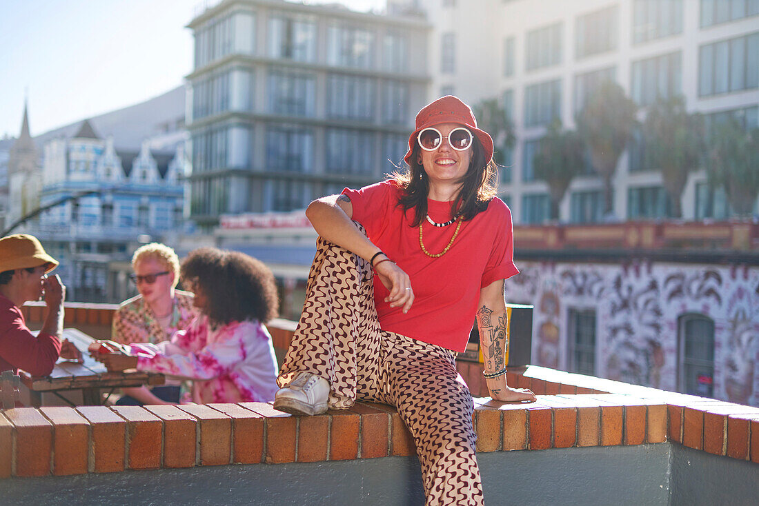 Young woman on sunny urban balcony
