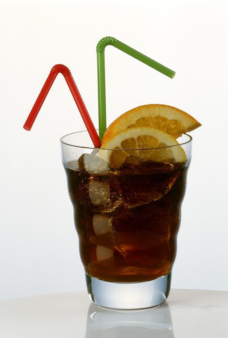 Glass of cola with ice cubes, lemon slices & 2 straws