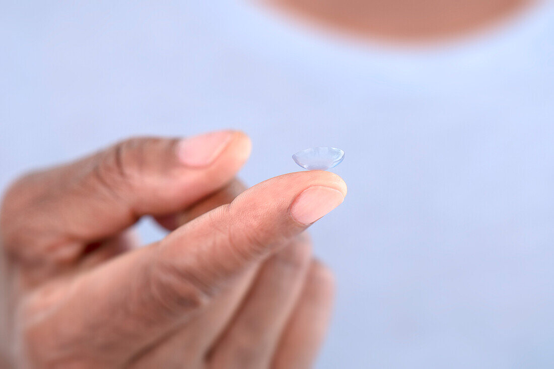 Contact lens on woman's finger