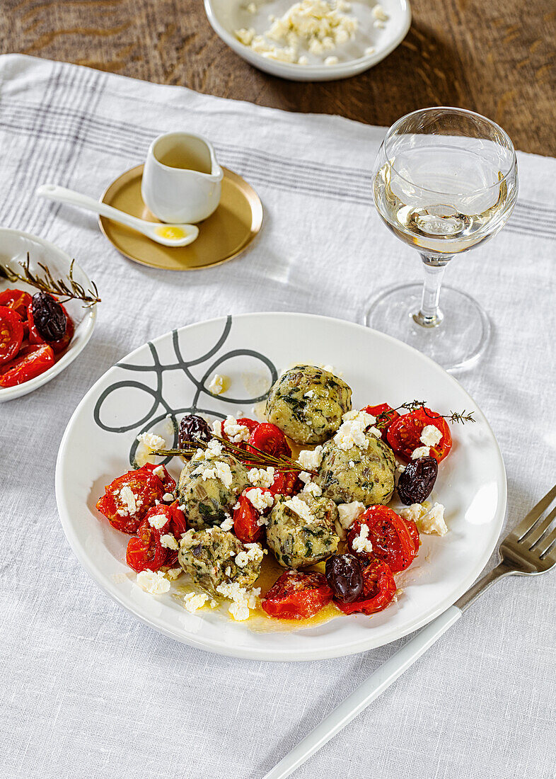 Chard and potato dumplings with olive and tomato glaze