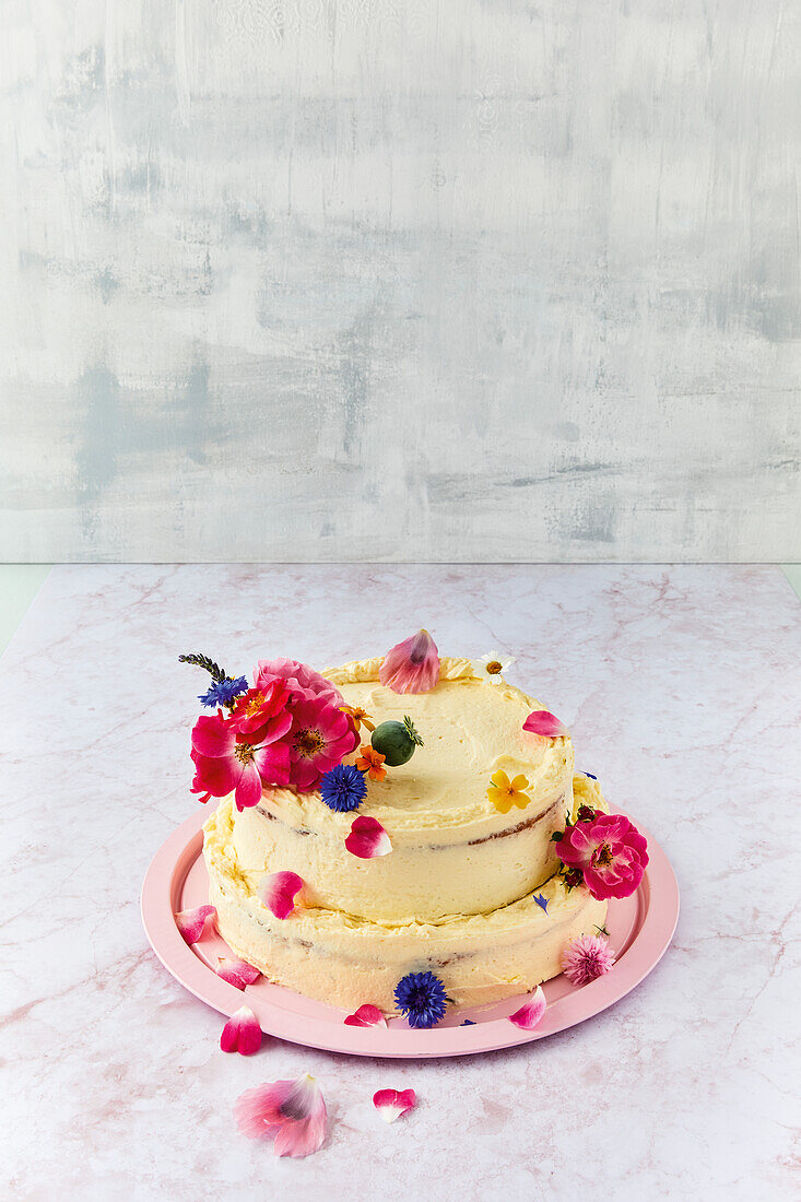 Two-tier celebration cake with vanilla cream and edible flowers
