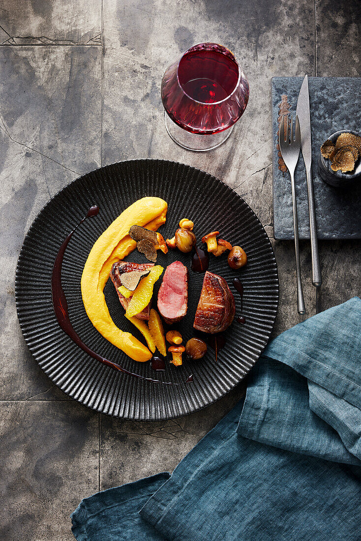 Pink roasted duck breast on orange sauce with sweet potato cream