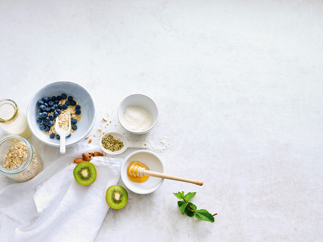 Zutaten für Müsli - Haferflocken, Kiwi, Mandeln, Honig