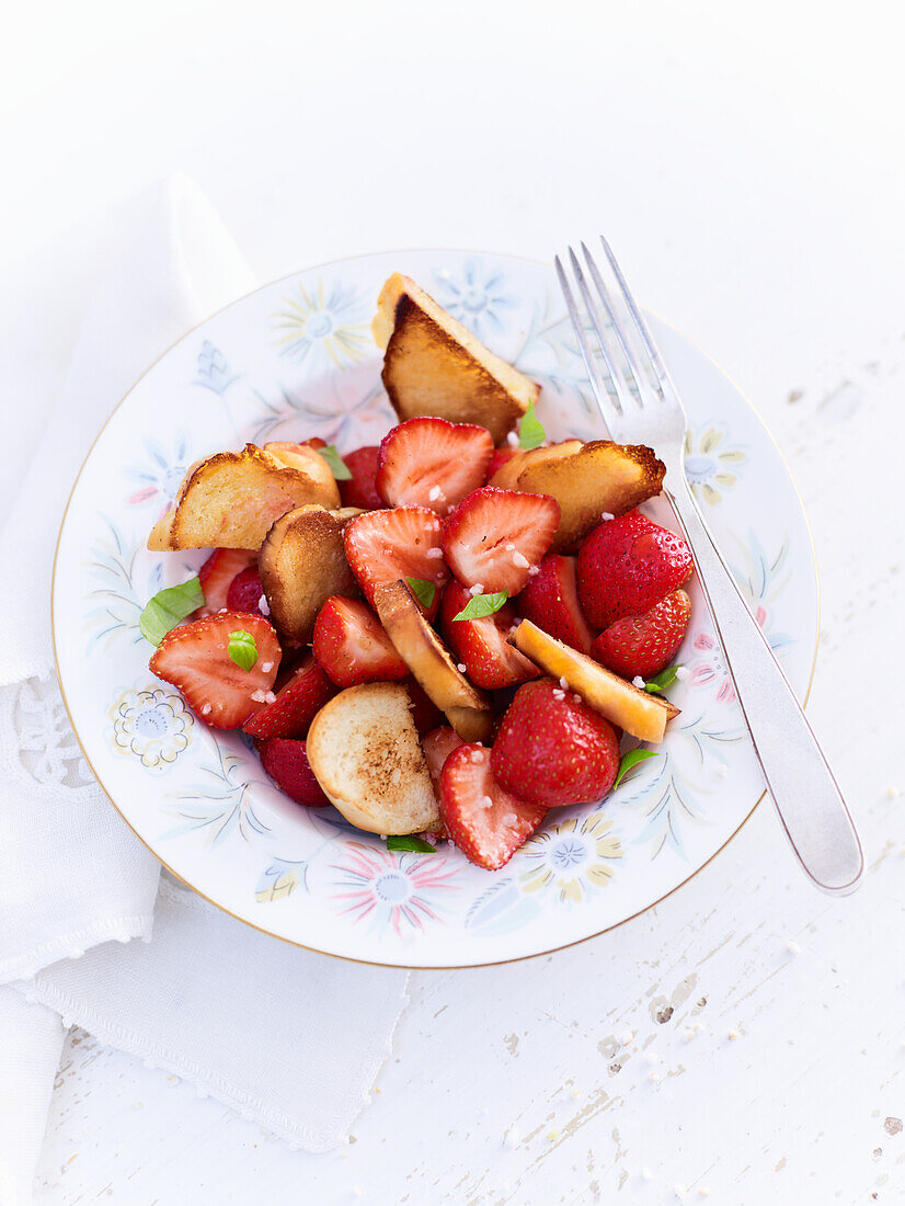 Strawberry salad with plaited bread rolls