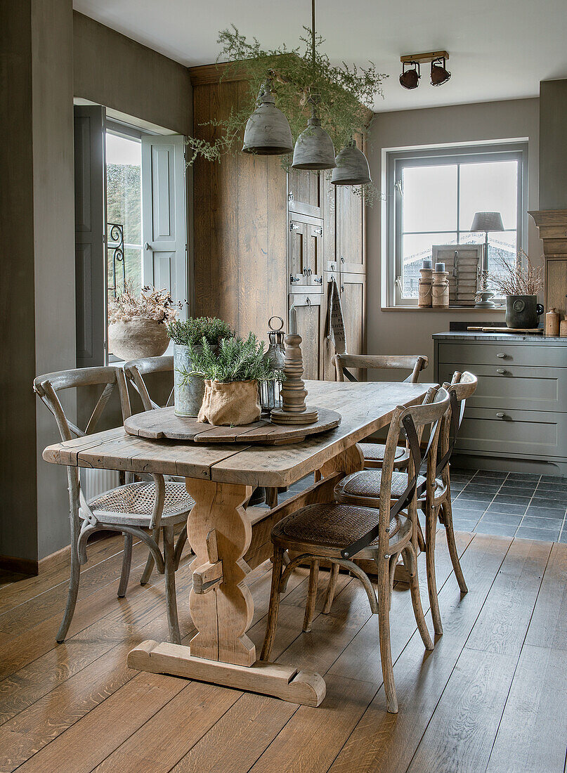 Rustikaler Esstisch mit Holzstühlen und Pflanzen in Esszimmer im Landhausstil