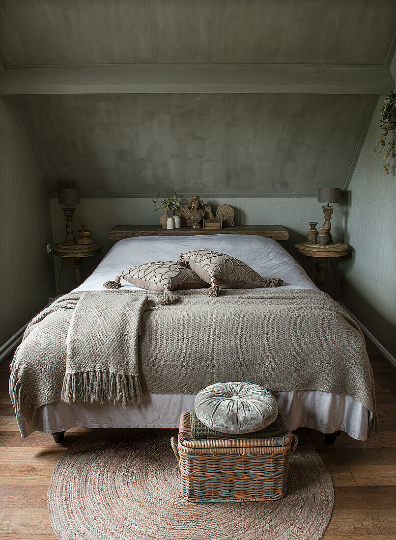 Attic bedroom with grey-painted walls and rustic wooden furniture