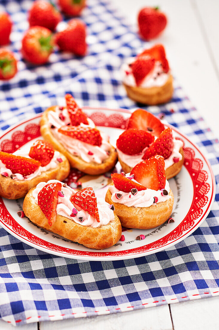 Profiteroles with whipped cream and strawberries