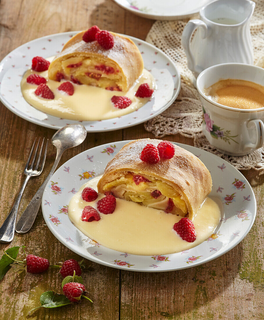 Apple strudel with vanilla sauce and raspberries