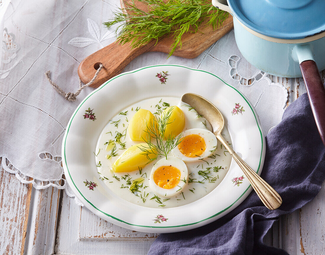 Hard-boiled eggs and potatoes in dill sauce