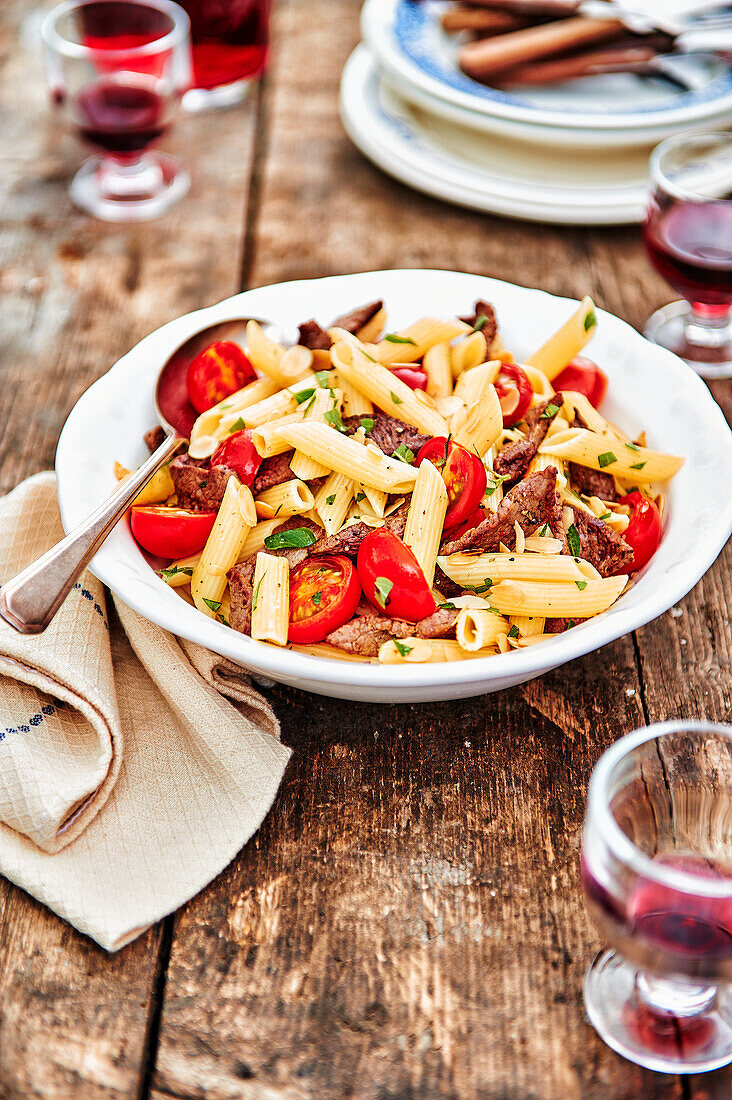 Penne with steak strips, almonds and tomatoes