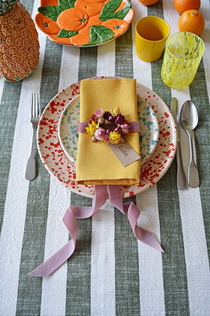 Gedeck mit getöpferten Tellern und getrockneter Blumendeko