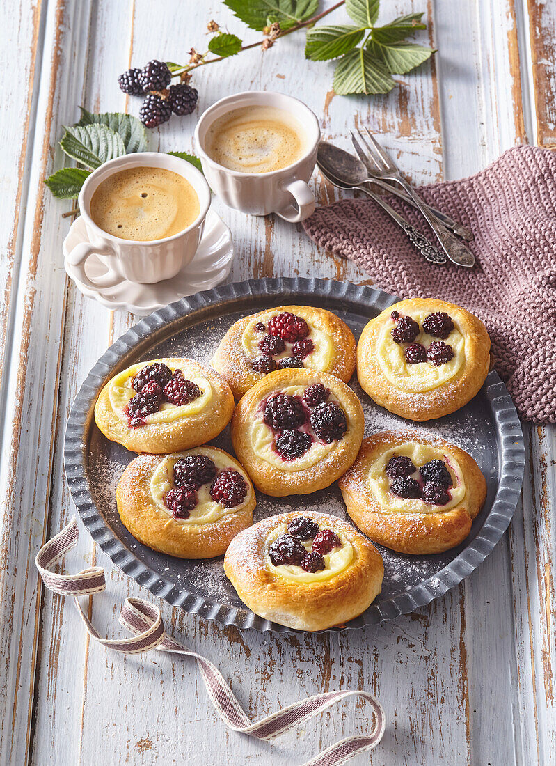 Round yeast cake with pudding and blackberries