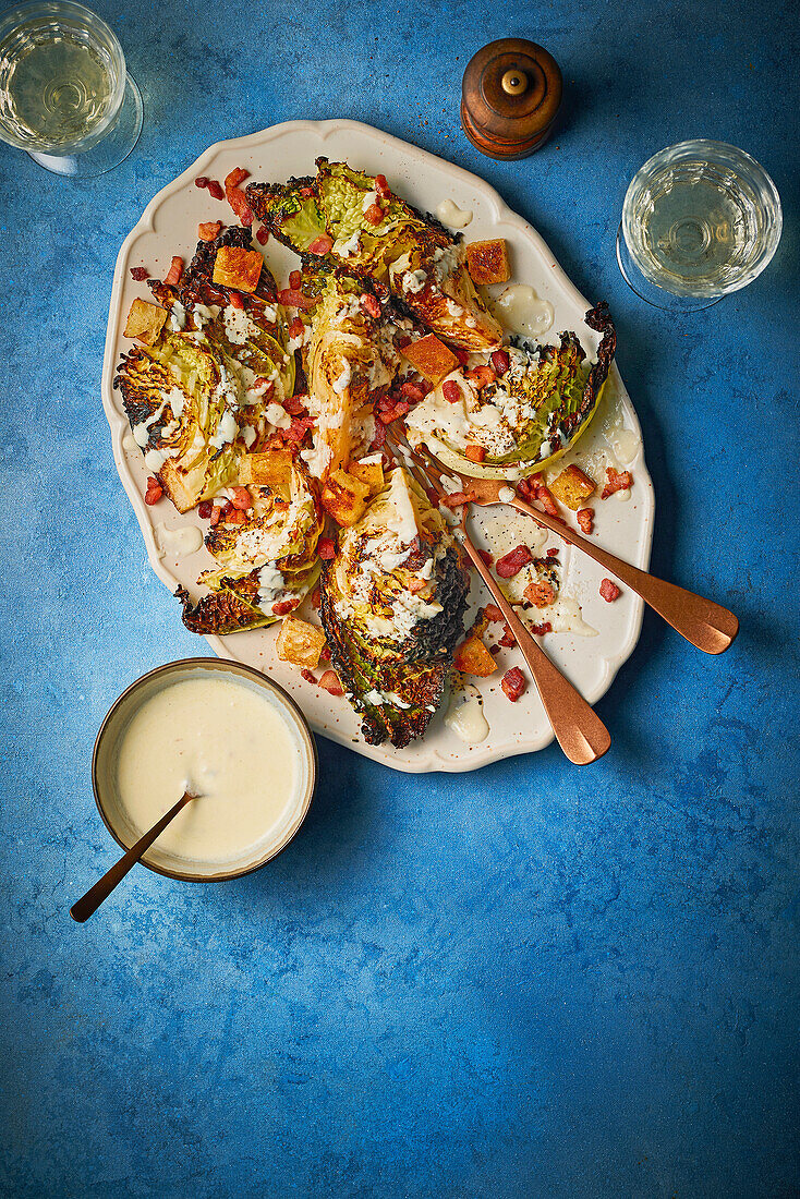 Grilled savoy cabbage with Caesar dressing and bacon croutons