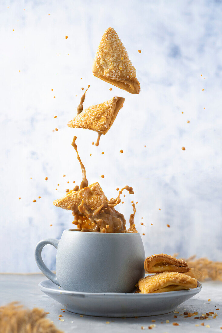 Puff pastry pastry falling into a cup of coffee