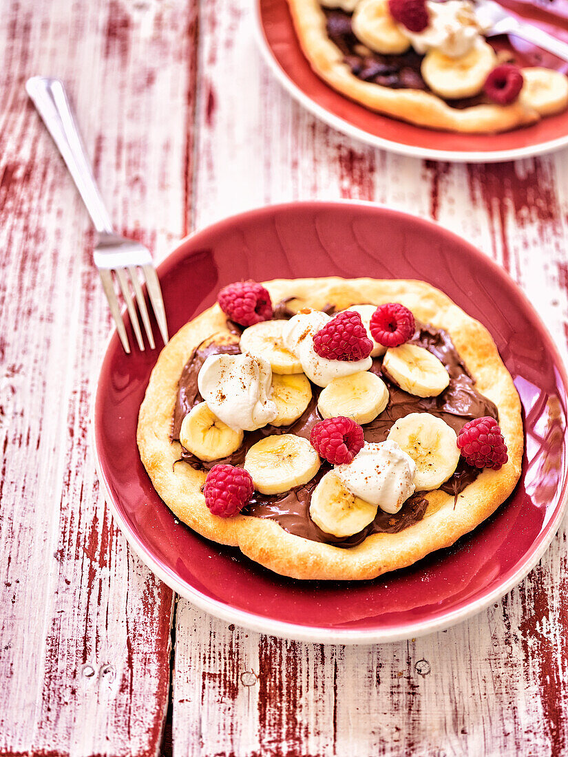 Chocolate cream pizza with bananas and raspberries