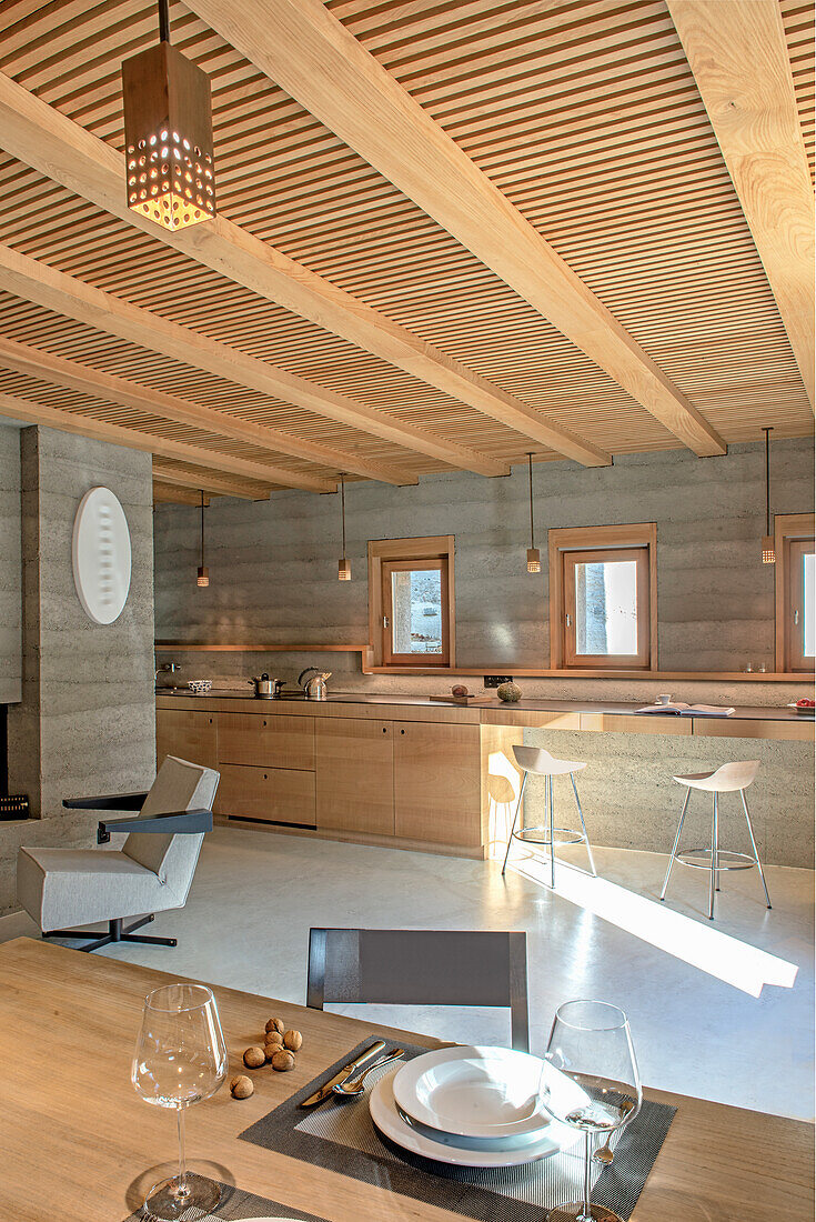 Moderne Küche mit Holzelementen und integrierter Essbereich