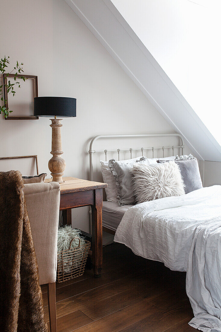 Bedroom with sloping ceiling, wooden floor and rustic work table