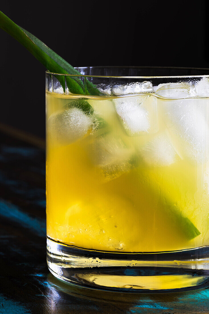 Yellow cocktail with ice cubes