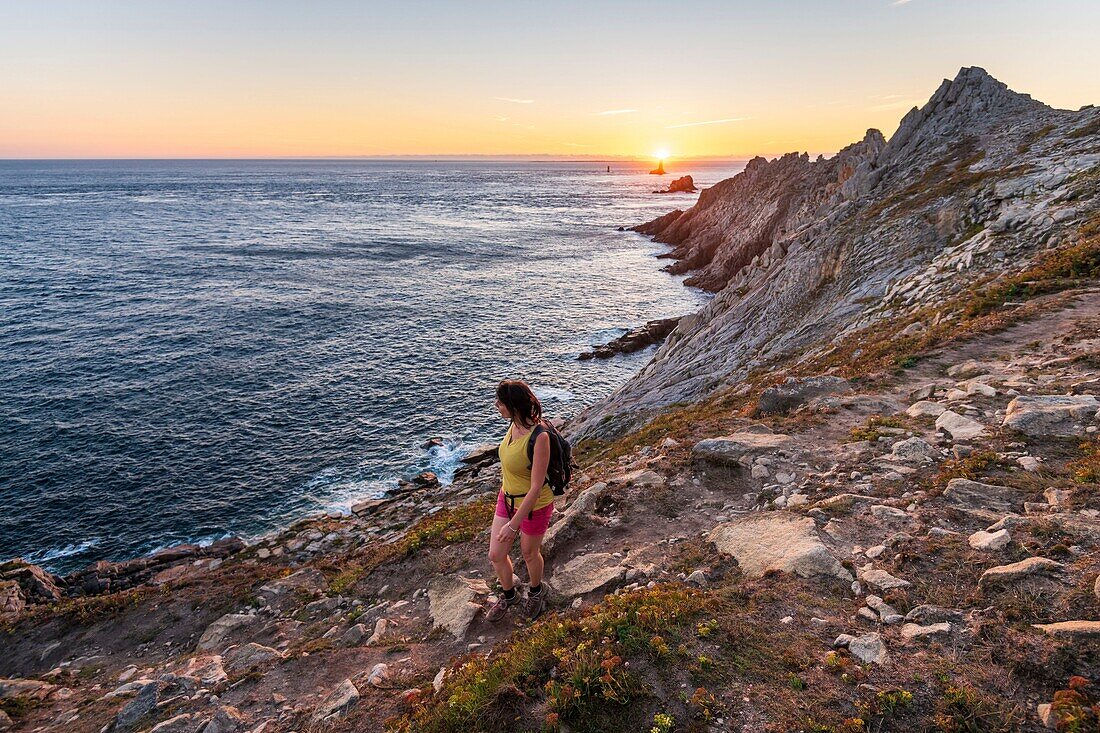 Frankreich,Finistere,Plogoff,Wanderer bei Sonnenuntergang an der Pointe du Raz