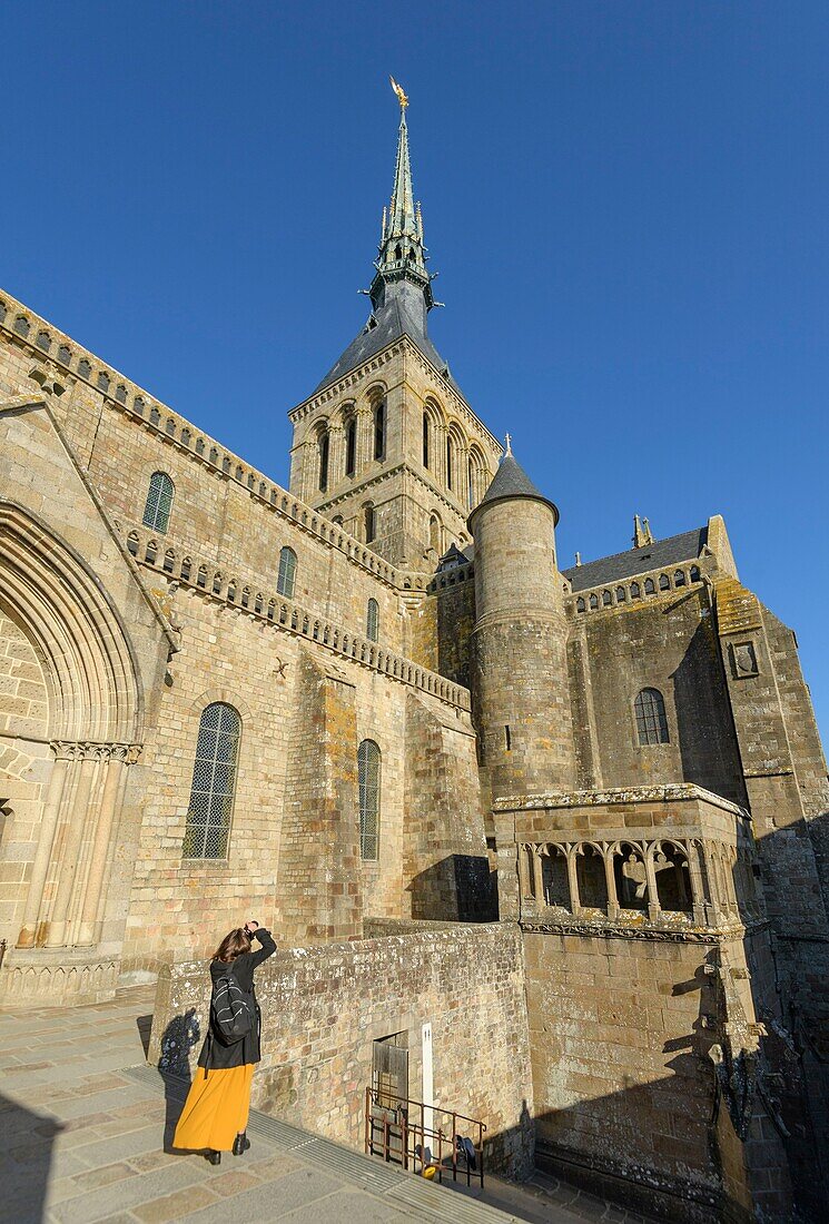 France,Manche,the Mont-Saint-Michel,woman photographing the abbey church