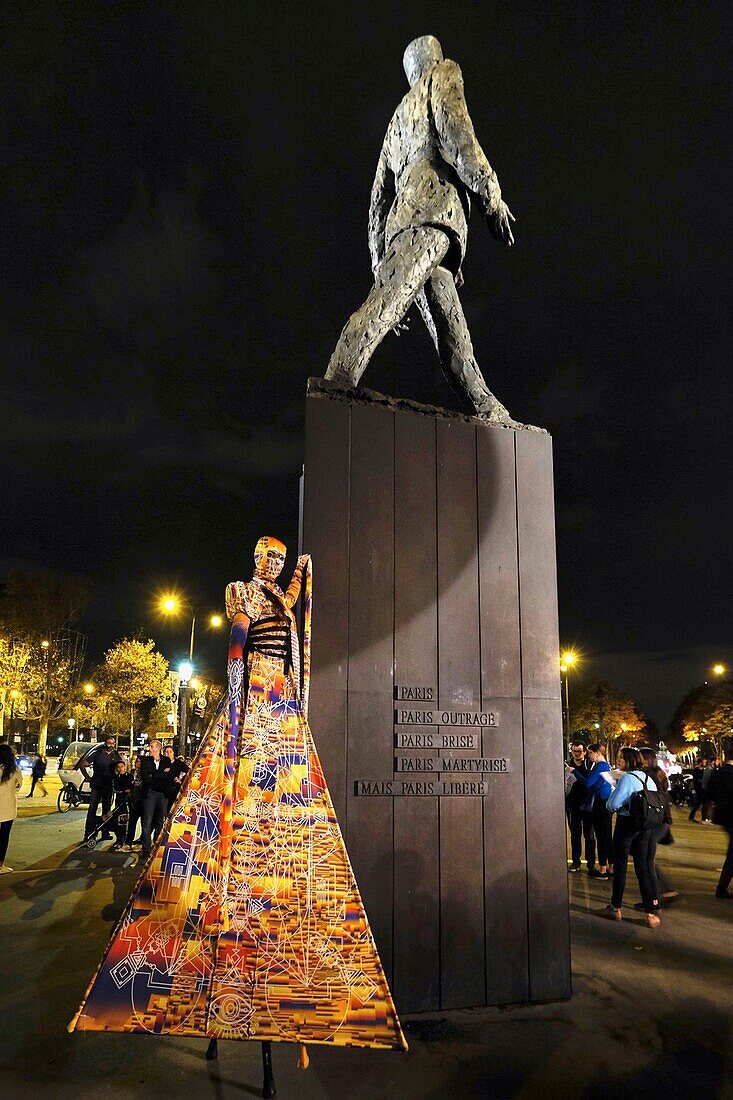 Frankreich,Paris,av. des Champs Elysees,Afrikanisches Mädchen in einem stilisierten Kleid auf ihren Stelzen vor der Statue von General de Gaulle während der Nuit Blanche Constellation des Invalides
