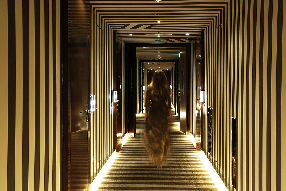 Frankreich,Paris,Royal Monceau Hotel,Frau im Abendkleid in einem Korridor mit grafischen Motiven des Royal Monceau