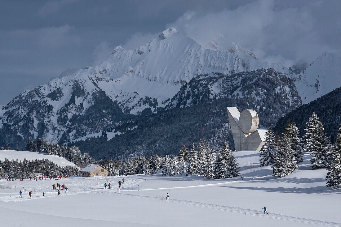Frankreich,Haute Savoie,Bornes-Massiv,Glieres-Plateau,Skating-Skifahrer auf Langlaufloipen und das nationale Denkmal des Widerstands von Emile Gilioli und der Gipfel des Jalouvre
