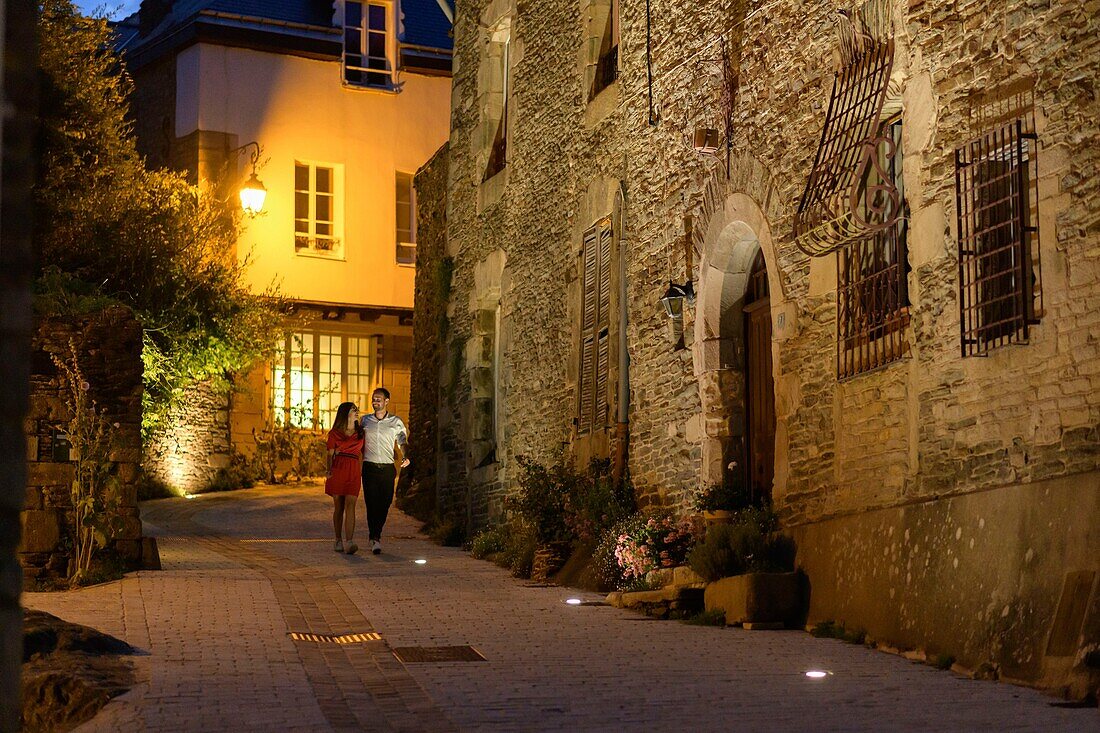 France,Morbihan,Josselin,couple going down the street of Val d'Oust a summer evening
