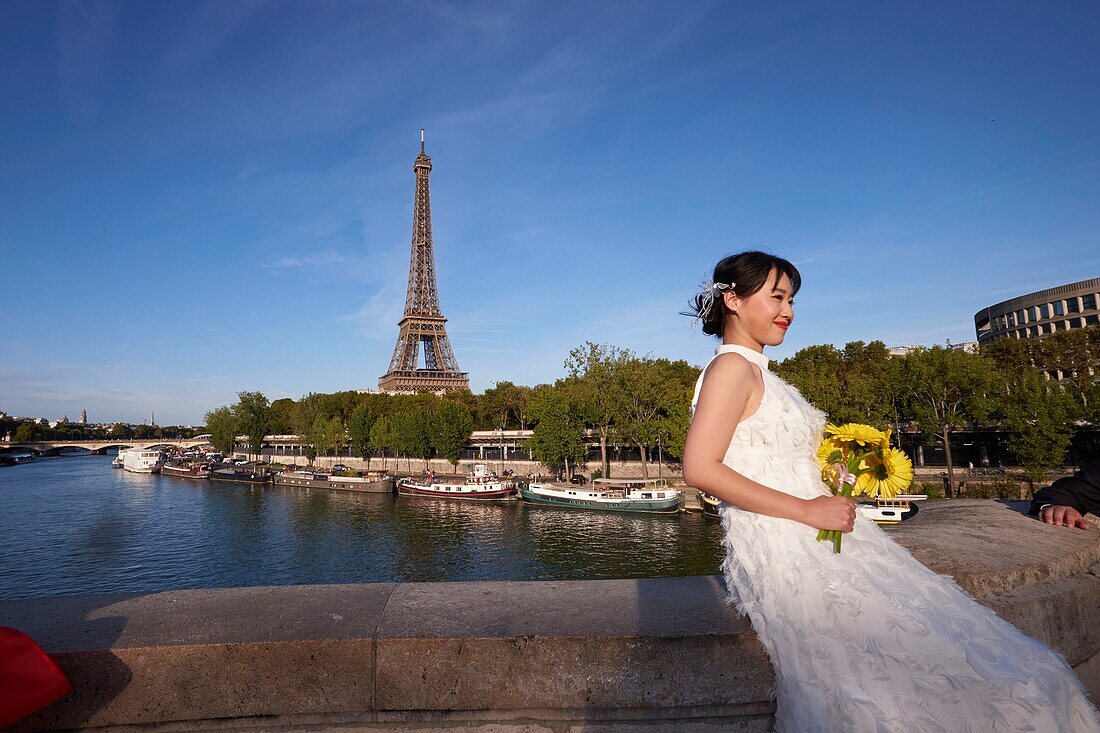 France,Paris,area listed as World Heritage by UNESCO,photo of an asian bride in front of the Eiffel Tower from Bir Hakeim Bridge