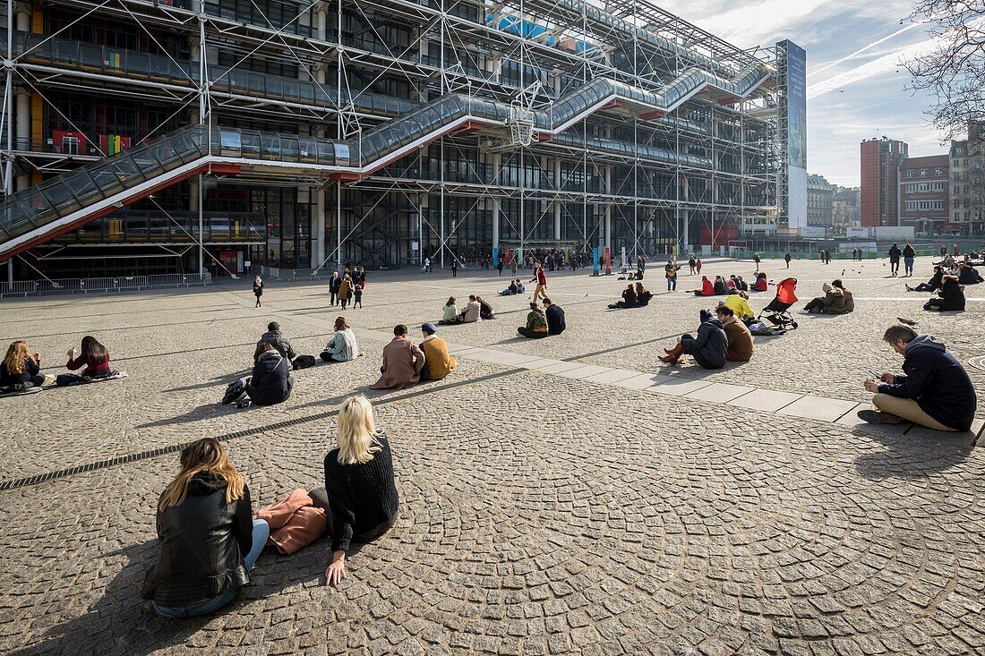 France,Paris,Les Halles district,tourists sitting on the forecourt of the Pompidou Center or Beaubourg,architects Renzo Piano,Richard Rogers and Gianfranco Franchini