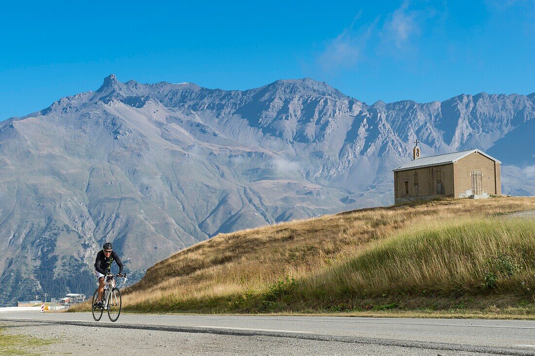 France,Savoie,Haute Maurienne,Val Cenis,Mont Cenis Pass,cyclist arriving at Saint Pierre Chapel and Vanoise Massif