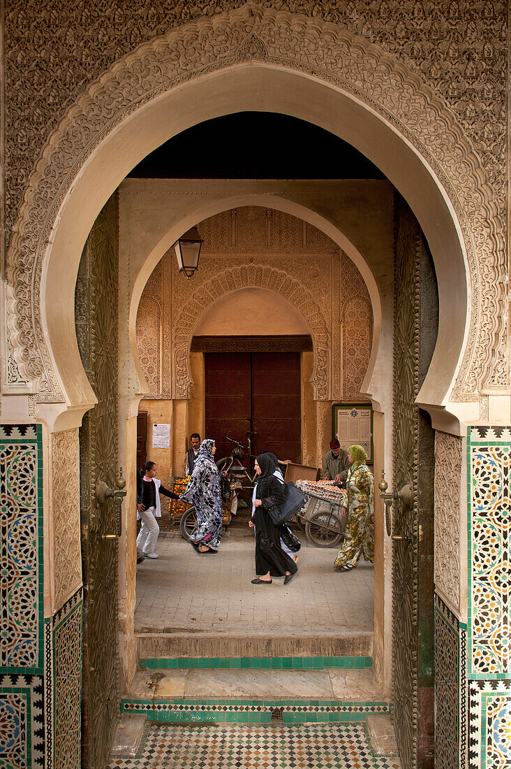 Morocco,People walking past entrance to Medersa Bou Inania,Fez