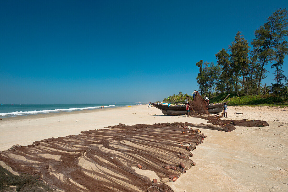 Indien,Fischer sortieren ihre Netze am Strand,Goa