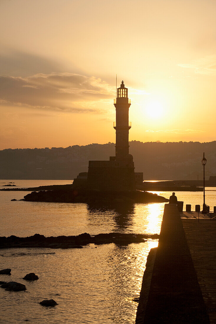 Greece,Crete,Silhouette of lighthouse at harbor entrance at dawn,Chania