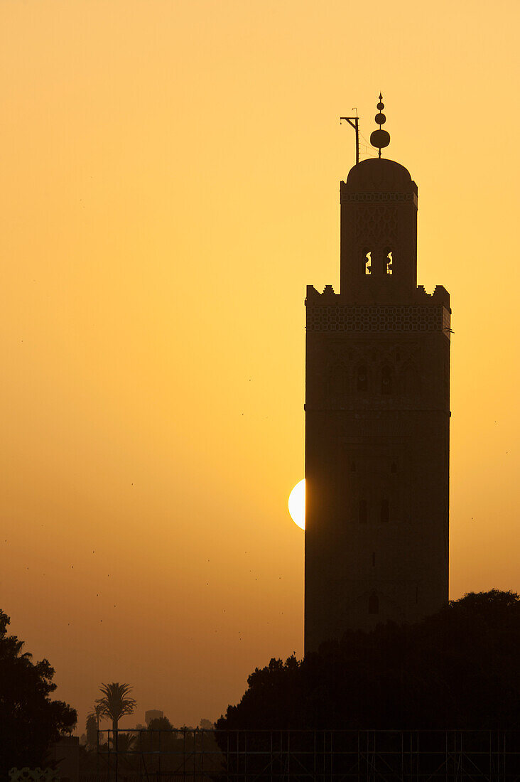 Morocco,Sun setting behind minaret of Koutoubia mosque,Marrakesh