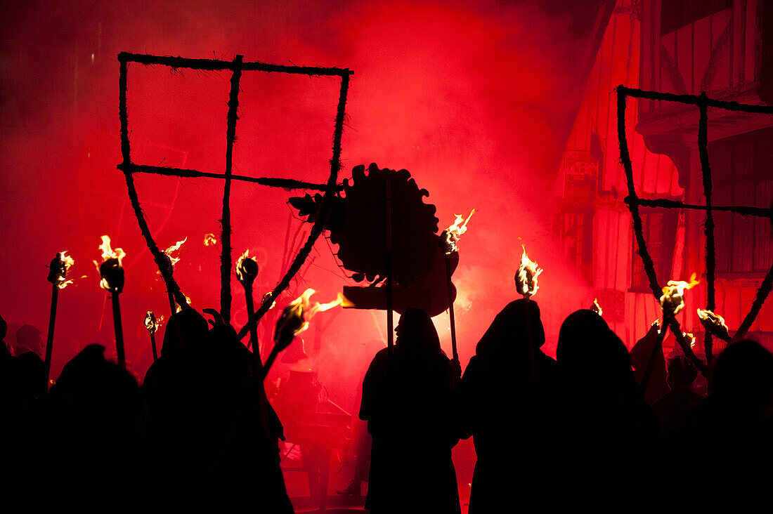 UK,England,East Sussex,Bonfire night,Lewes,Silhouetten von Mönchen der Southover Bonfire Society beleuchtet von roten Fackeln auf der United Grand Procession down High Street