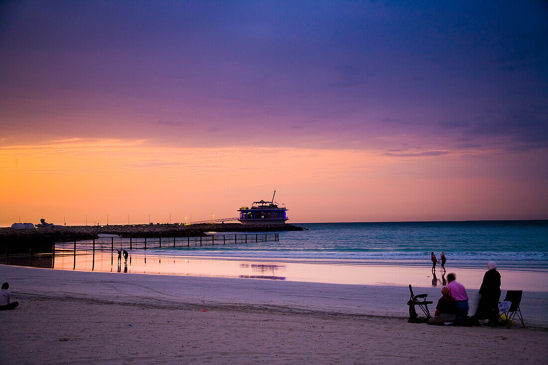 VAE,Menschen beobachten Sonnenuntergang am Jumeirah Beach,Dubai