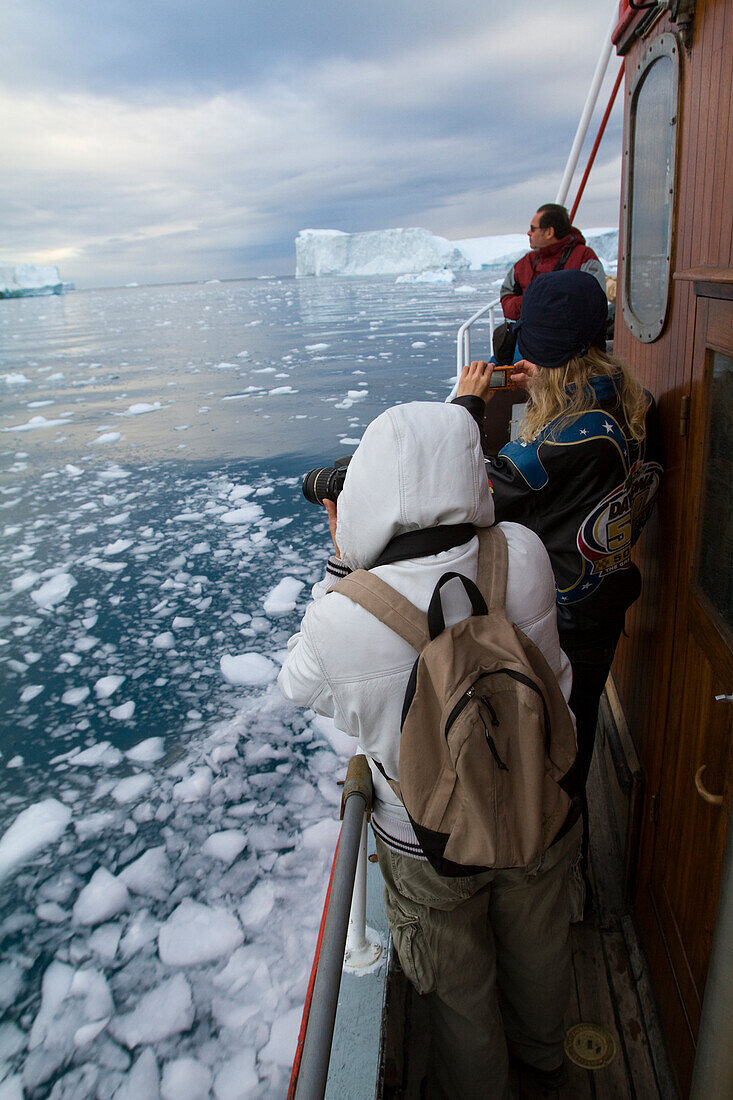 Besucher auf einer Mitternachtsfahrt um den Ilulissat-Eisfjord, eine der Unesco-Welterbestätten. Grönland.