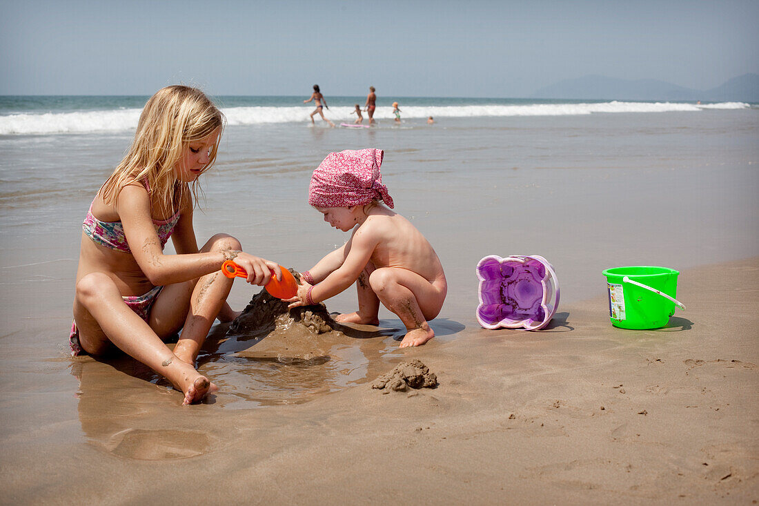 Kinder spielen zusammen im Urlaub und bauen Sandburgen,Turtle Beach,Goa,Indien.