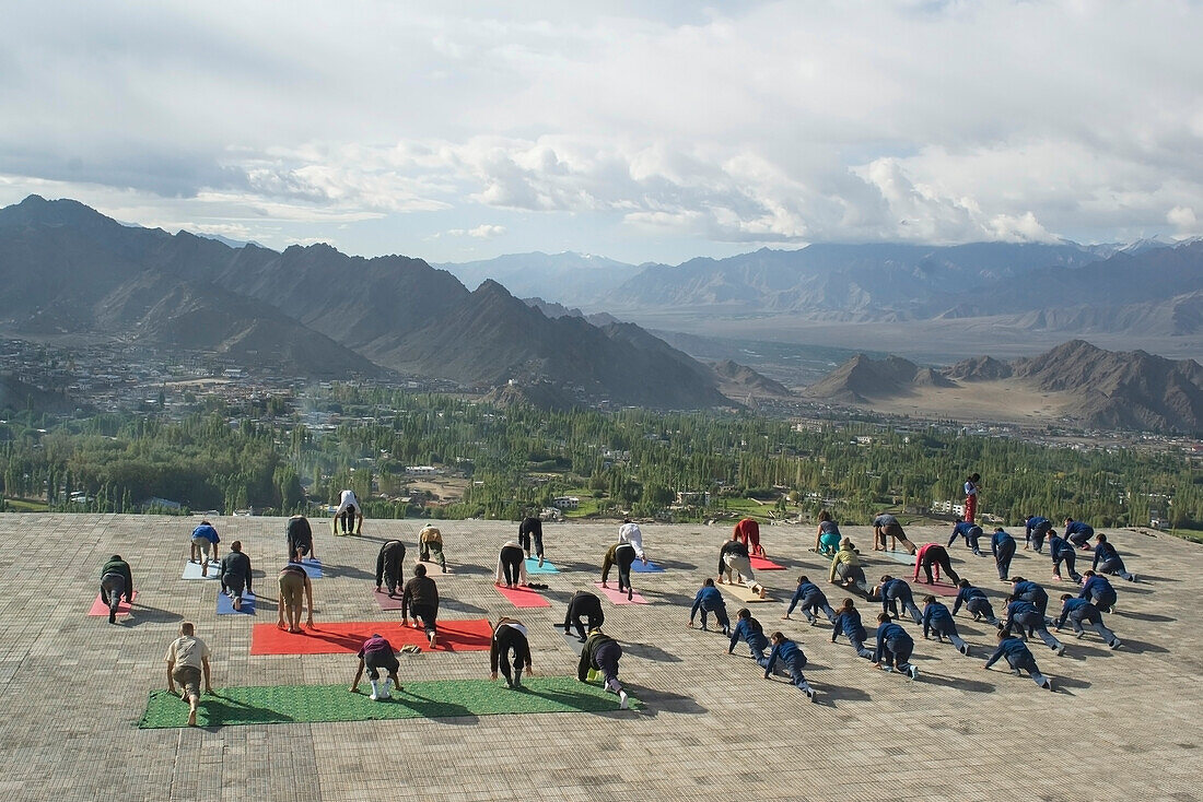Yogagruß an die Sonne vor der Shanti (Peace) Stupa oberhalb von Leh. Ladakh, Provinz Jammu und Kaschmir, Indien