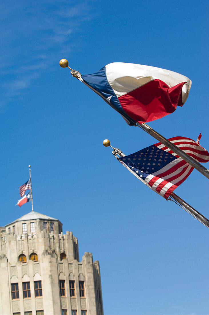 Altes San-Antonio-Nachrichtengebäude im Hintergrund mit Stars and Stripes (US-Flagge) und Lone Star (Texas-Flagge) im Vordergrund, San Antonio, Texas, USA