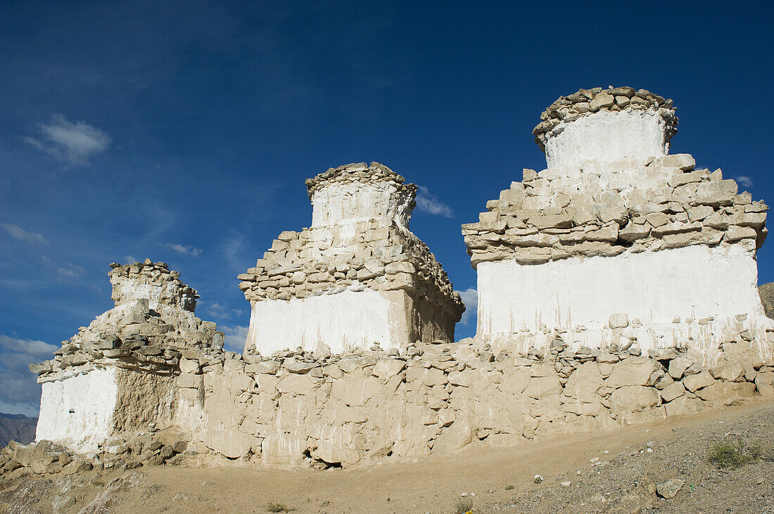 Buddhist chortens on a hill overlooking the Indus Valley and Leh. Leh was the capital of the Himalayan kingdom of Ladakh,now the Leh District in the state of Jammu and Kashmir,India. Leh is at an altitude of 3,500 meters (11,483 ft).