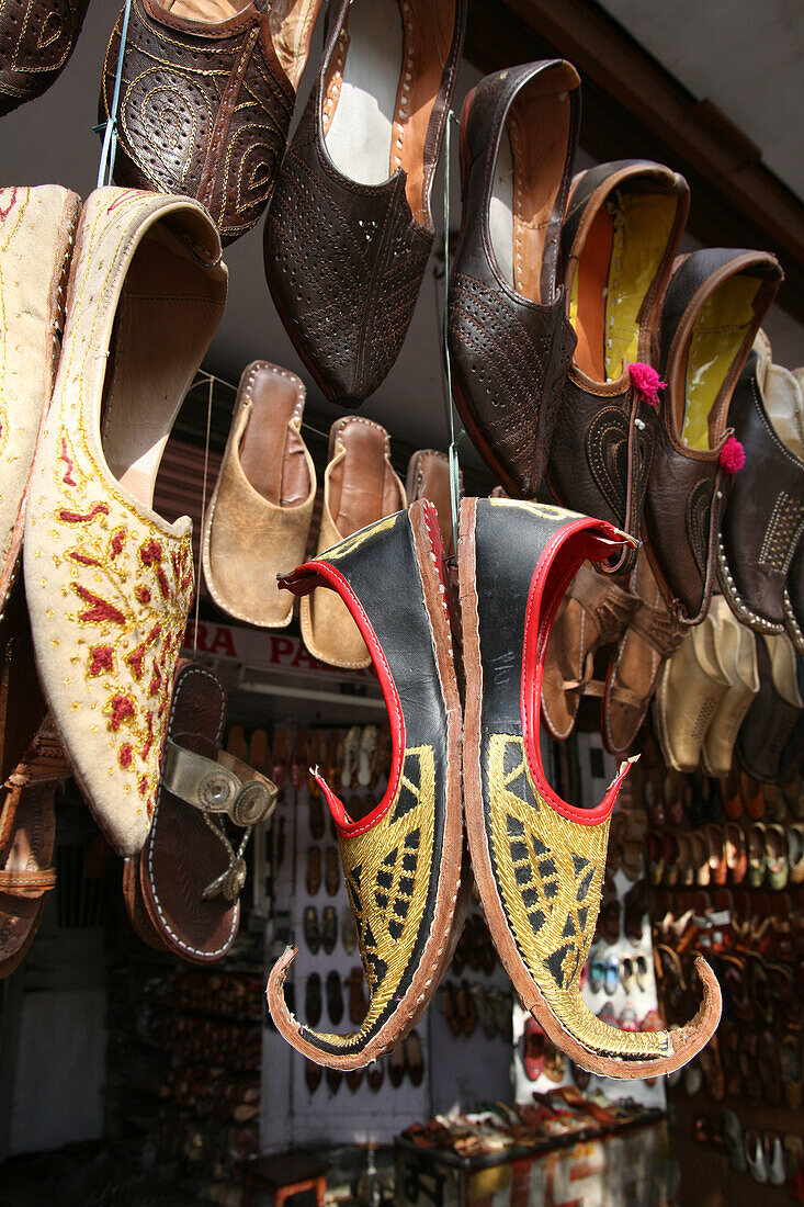 Lederschuhe und andere touristische Waren zum Verkauf in diesem Geschäft in der Nähe des Hawa Mahal City Palace, Jaipurs Wahrzeichen, Jaipur, Rajasthan State, Indien.